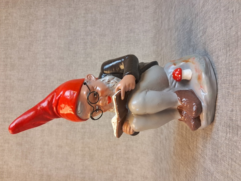 HEISSNER. Tomte med glasögon, läser bok.