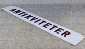 Äldre skylt. "ANTIKVITETER", plast, upphöjda bokstäver.