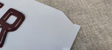 Äldre skylt. "ANTIKVITETER", plast, upphöjda bokstäver.