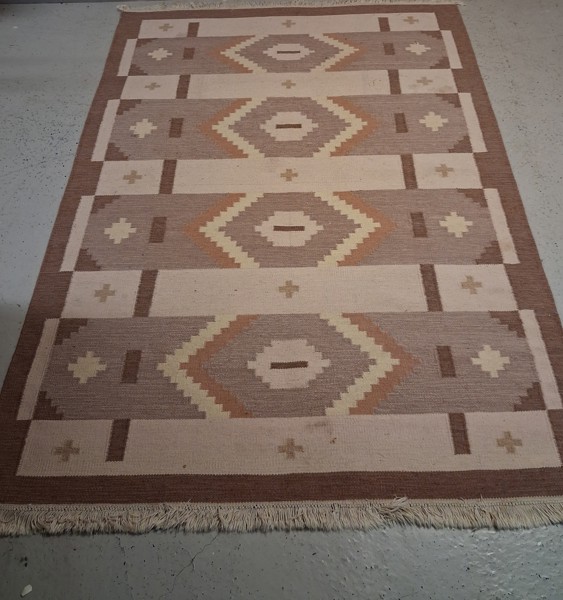 Röllakan matta, osignerad i brun & svag rosa nyans.