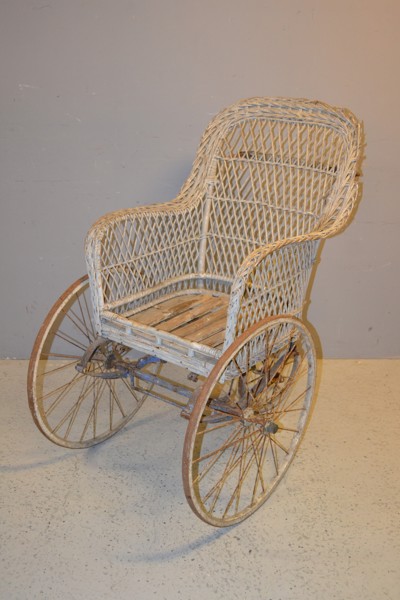 Äldre rullstol. Början på 1900-talet, trä, rotting & metall.