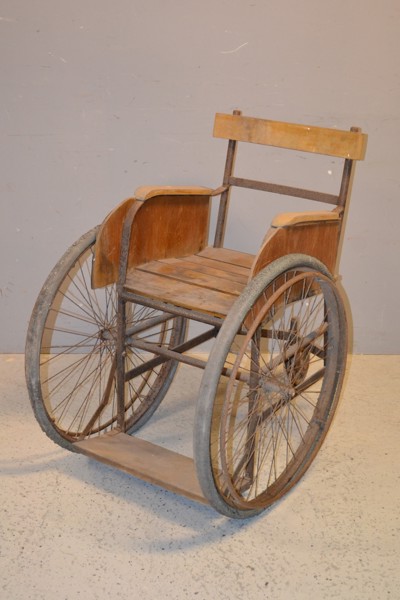 Äldre rullstol. 1900-talets första hälft, trä & metall.