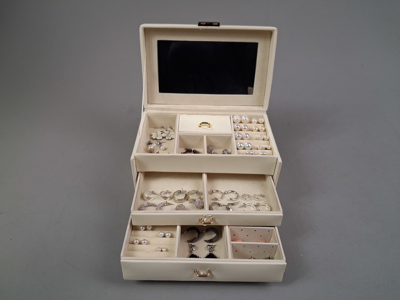 Smyckesskrin i konstskinn med diverse öronhängen.