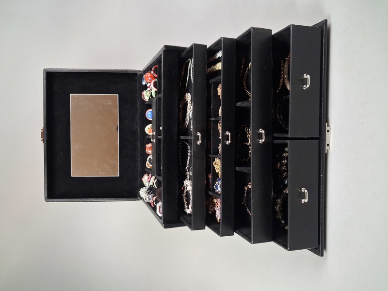 Smyckesskrin i konstskinn. Full med diverse bijouterier.