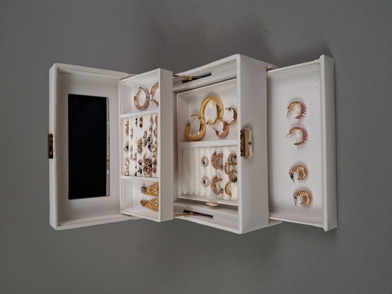 Smyckesskrin i konstskinn med diverse öronhänge.
