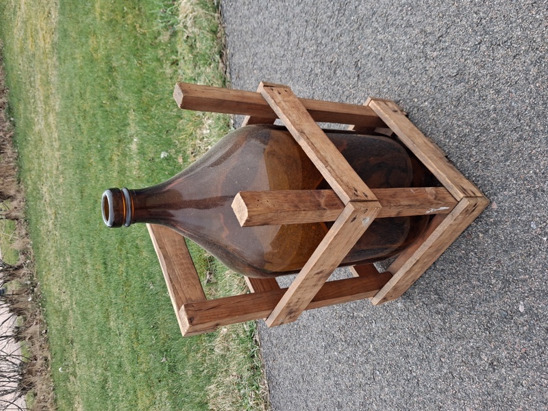 Damejeanne med trähållare.