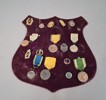 Märkessköld med medaljer. Bl.a 3st silver cirka 36gram.