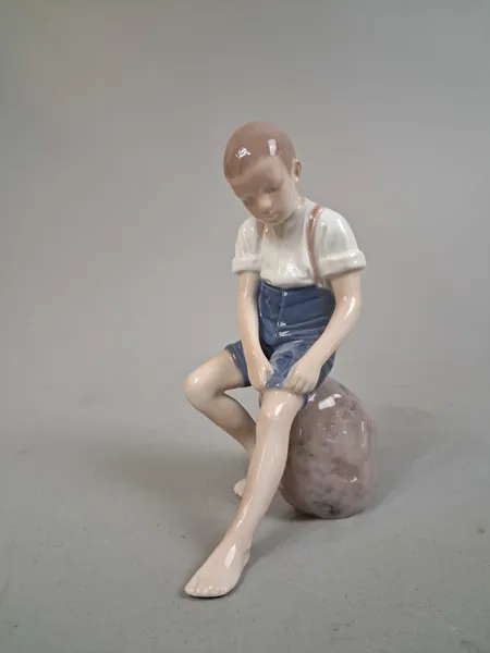 Figurin. Porslin, "Pojke på sten", Bing & Gröndal.