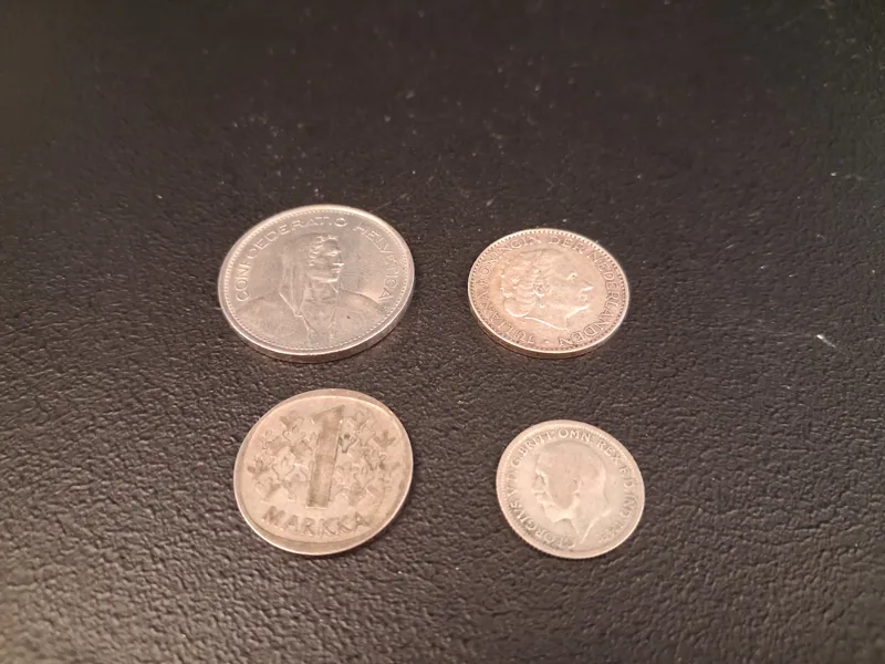 Utländska silvermynt. 1 Markka 1964, 6 Pence 1928, 1 Gulden 1958 & 5 Franc 1968.