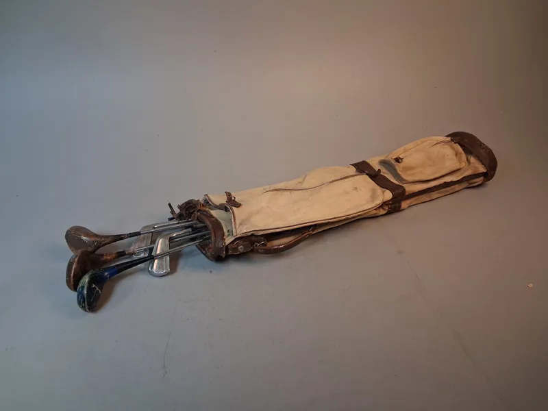 Äldre golfbag med klubbor.