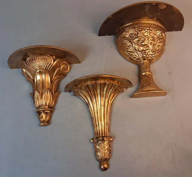 3 Guldfärgade vägghyllor.