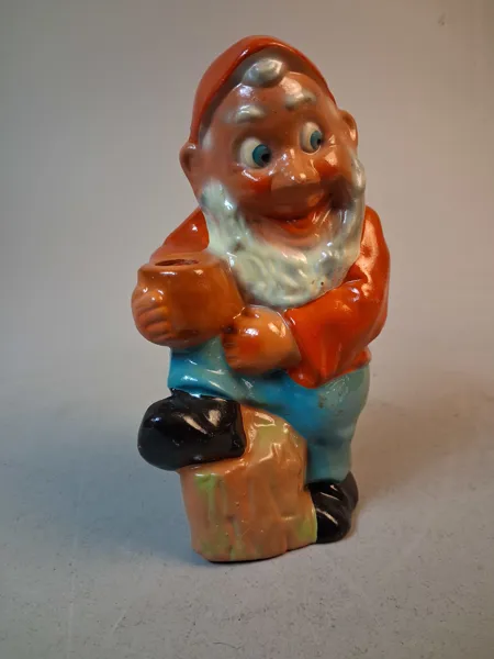 Tomte, figurin, terrakotta. "Tomte som luta sig mot stubben & håller en ljushållare", Tyskland.