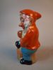 Tomte, figurin, terrakotta. "Tomte som luta sig mot stubben & håller en ljushållare", Tyskland.
